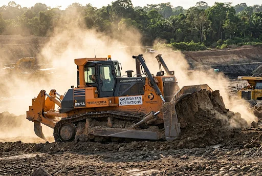 Heavy-duty crawler bulldozer moving earth at a mining site in Kalimantan