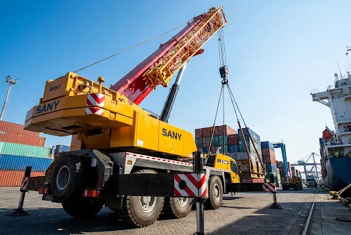 Large yellow mobile crane operating at an industrial port in Balikpapan